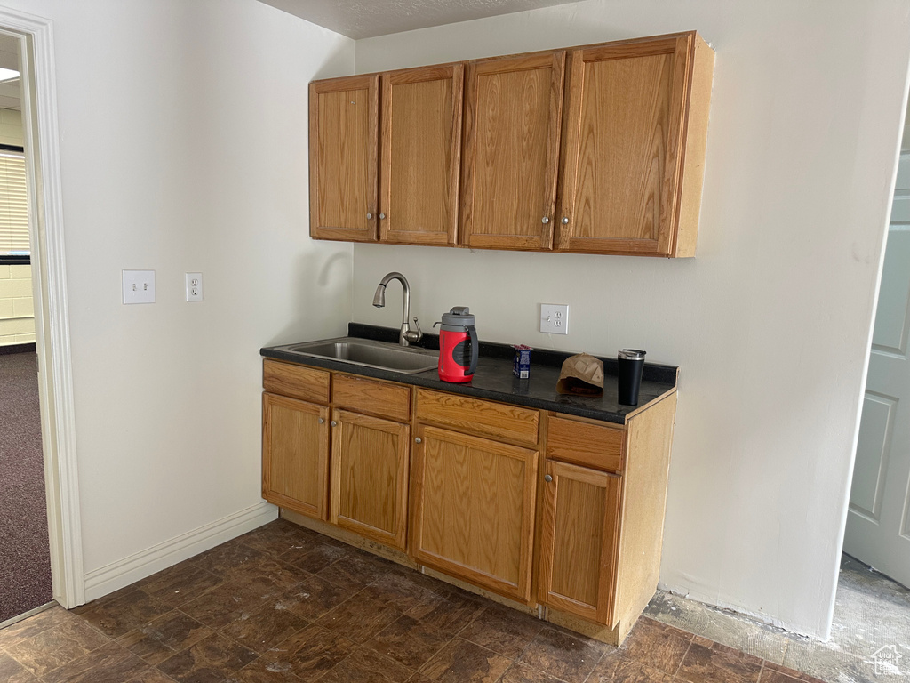 Kitchen featuring dark tile patterned floors and sink