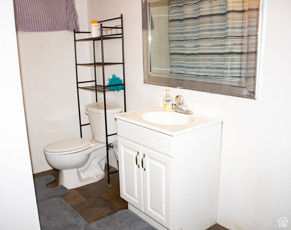 Bathroom with vanity, toilet, and tile patterned floors