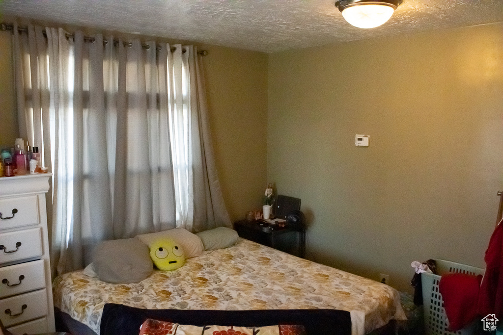 Bedroom with multiple windows and a textured ceiling