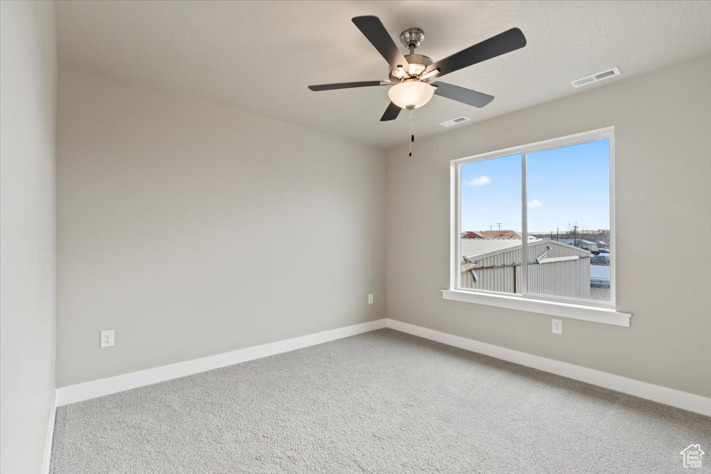 Carpeted spare room with ceiling fan
