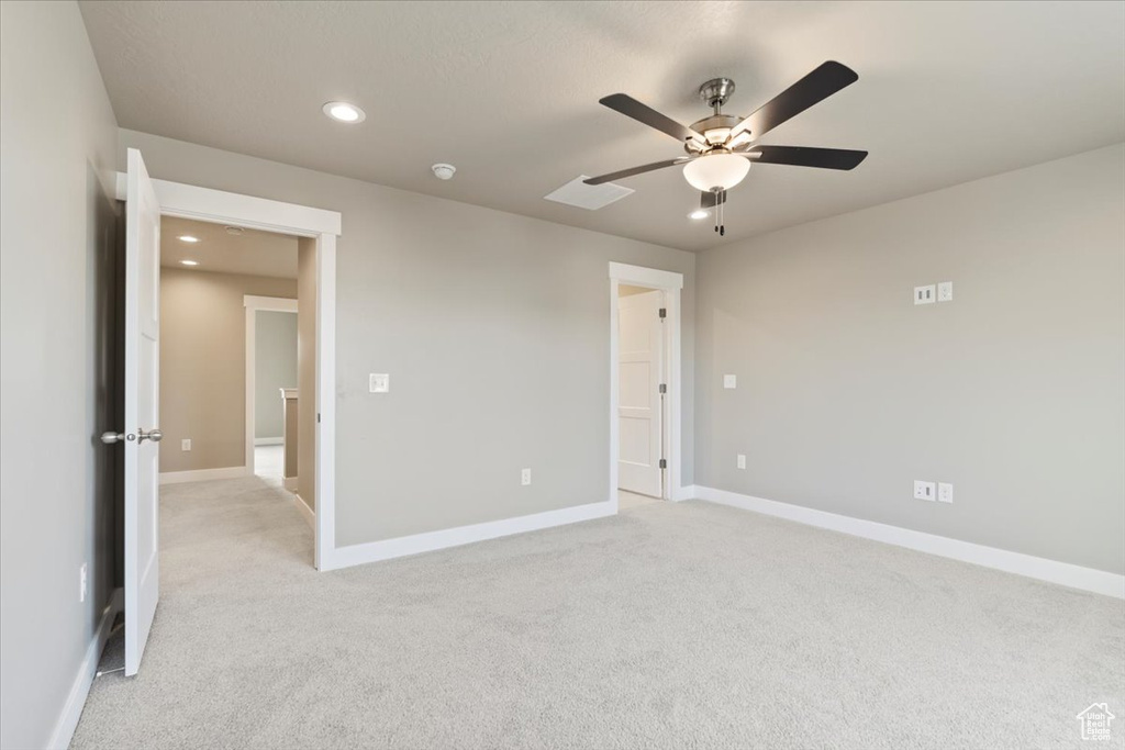 Unfurnished bedroom with ceiling fan and light colored carpet