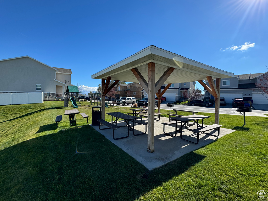 View of community featuring a patio area, a lawn, and a playground