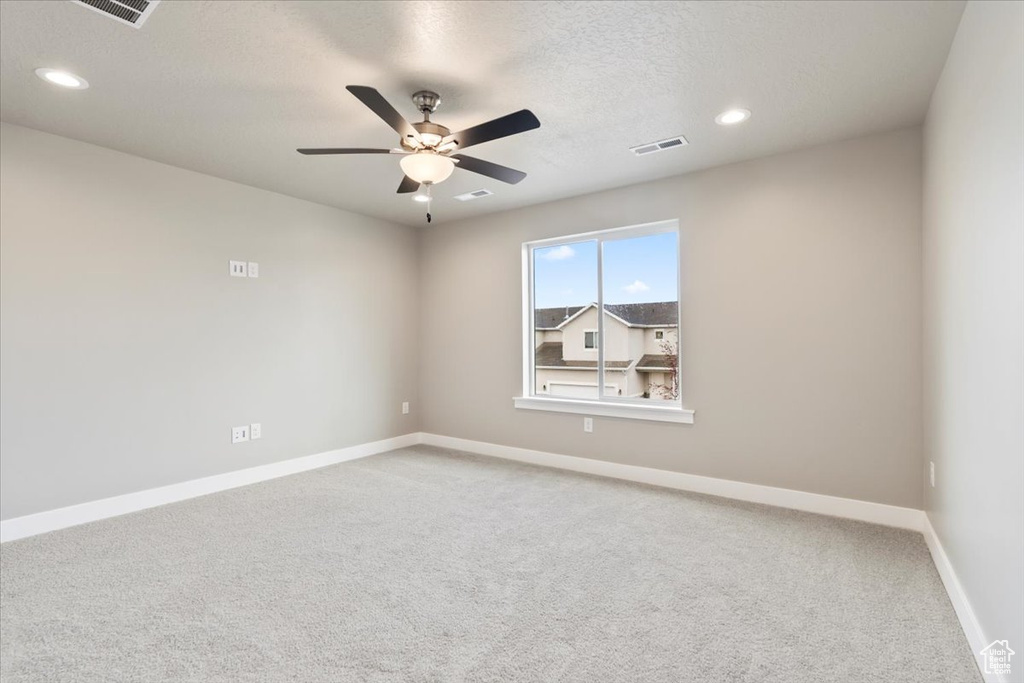 Spare room featuring ceiling fan, carpet floors, and a textured ceiling