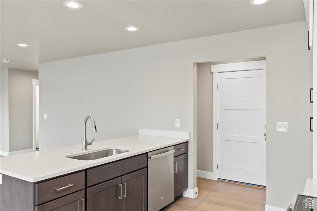 Kitchen featuring sink, light hardwood / wood-style flooring, dishwasher, dark brown cabinetry, and kitchen peninsula