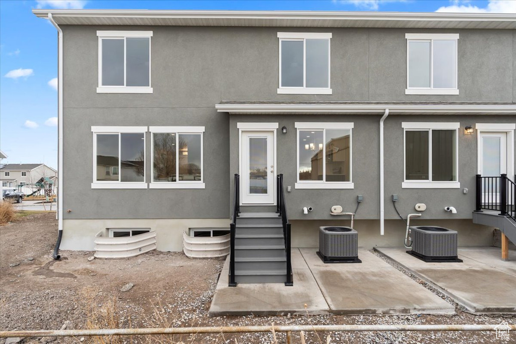 Rear view of house with central AC unit and a patio area