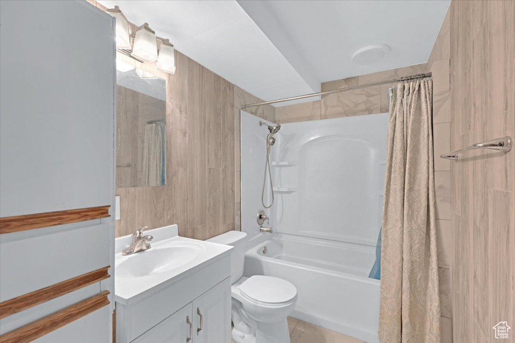 Full bathroom featuring tile patterned flooring, shower / bathtub combination with curtain, toilet, and vanity