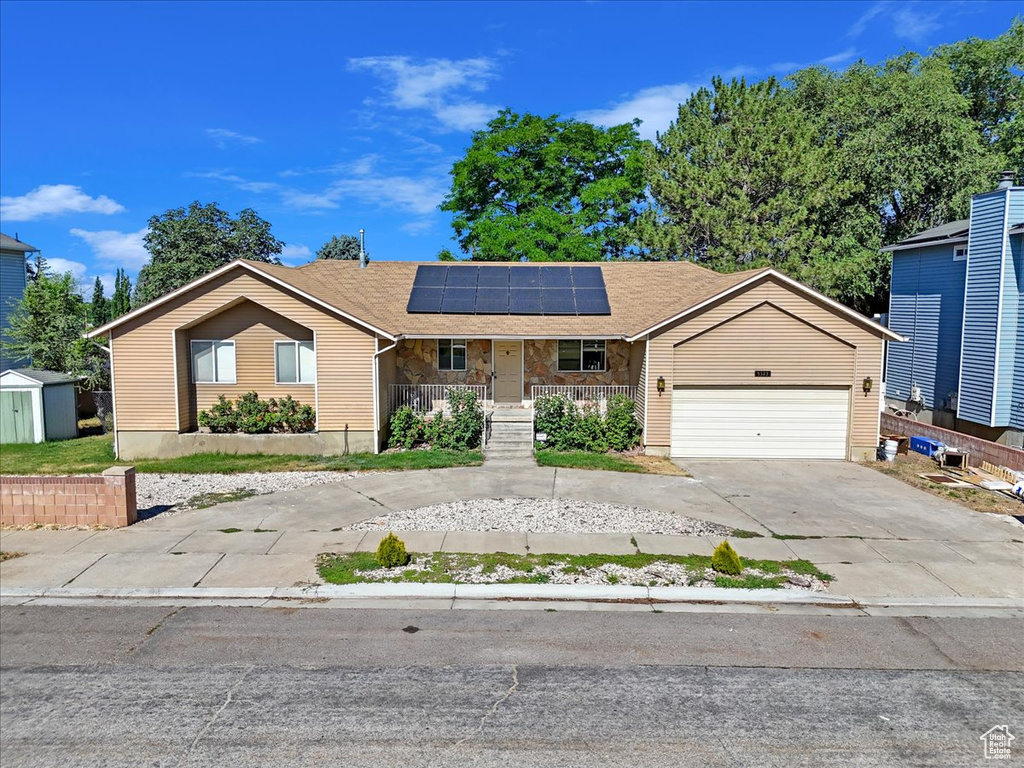 Ranch-style house with a garage and solar panels