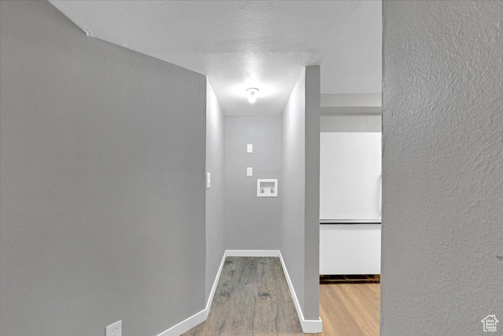 Hall featuring a textured ceiling and wood-type flooring