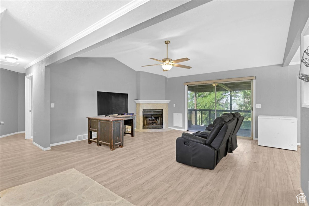 Living room with ceiling fan, light hardwood / wood-style flooring, and lofted ceiling