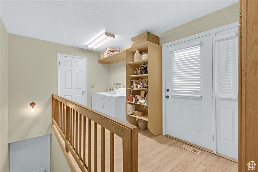 Hall featuring light hardwood / wood-style floors and separate washer and dryer