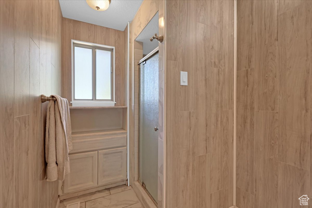 Bathroom featuring a shower with shower door and tile patterned flooring