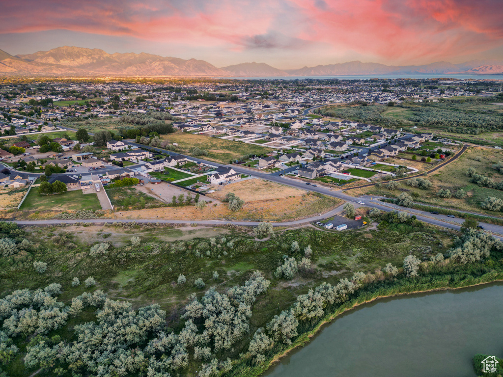 Aerial view at dusk featuring a water and mountain view