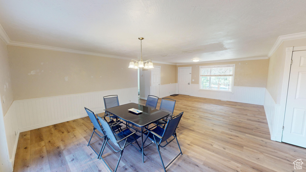 Dining area featuring crown molding, light hardwood / wood-style flooring, and a chandelier