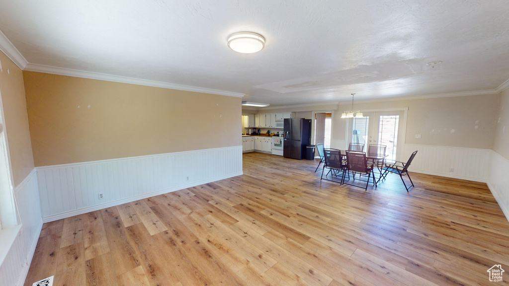 Spare room featuring light wood-type flooring and crown molding