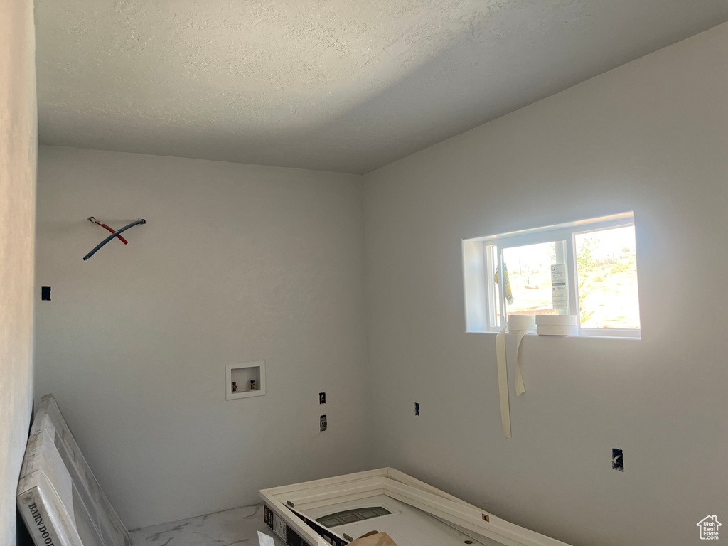 Laundry room with a textured ceiling and washer hookup