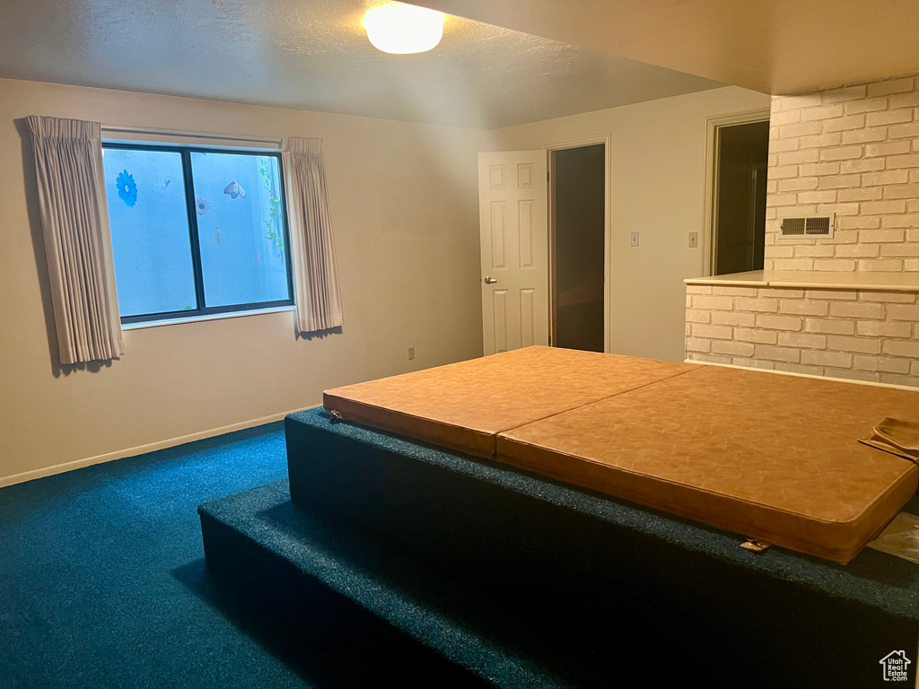 Carpeted bedroom with brick wall