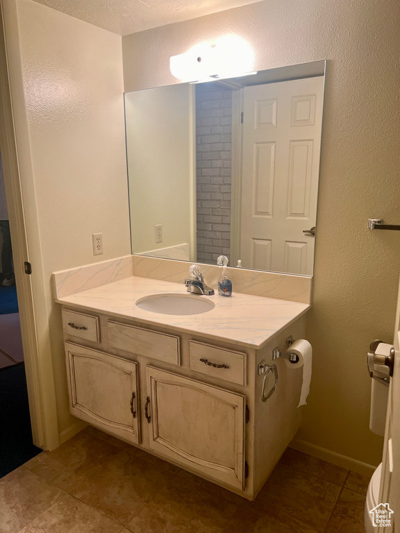 Bathroom with tile patterned floors, vanity, and a textured ceiling