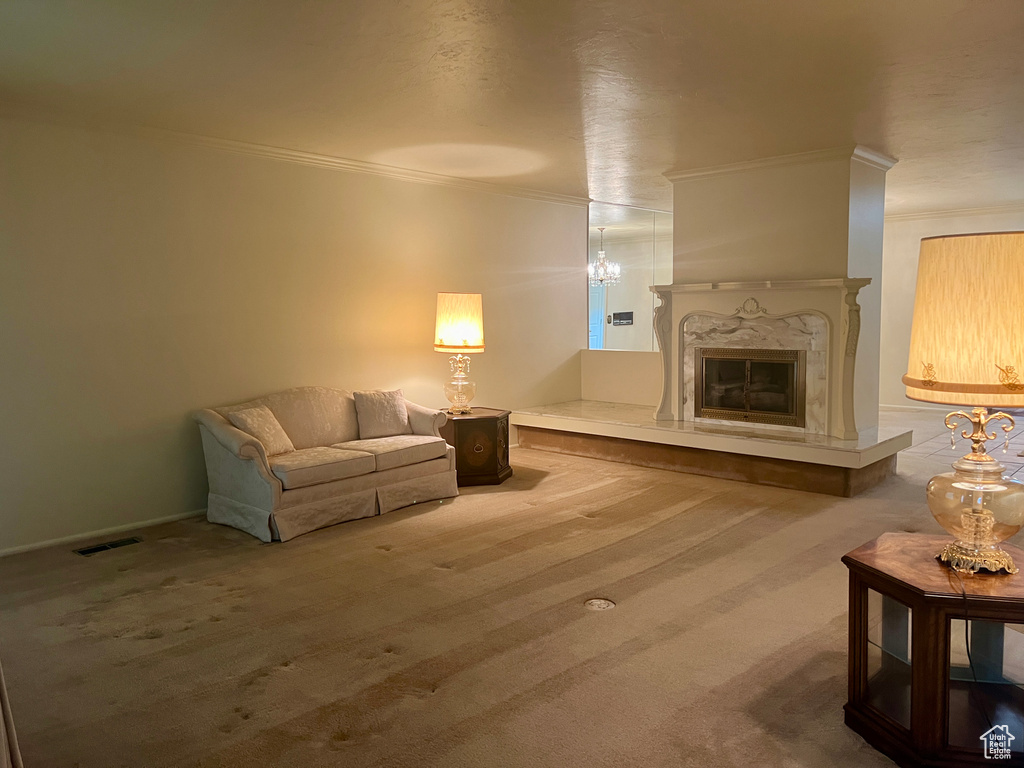 Interior space featuring a fireplace, a chandelier, crown molding, and carpet flooring