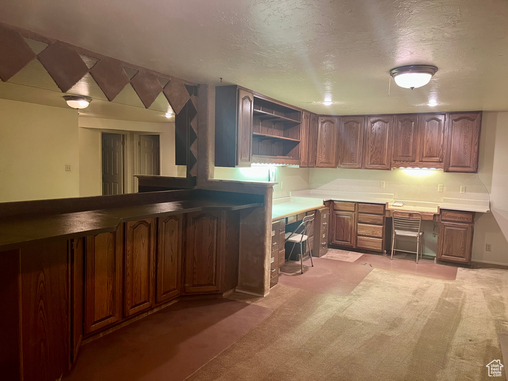 Kitchen with light carpet and a textured ceiling