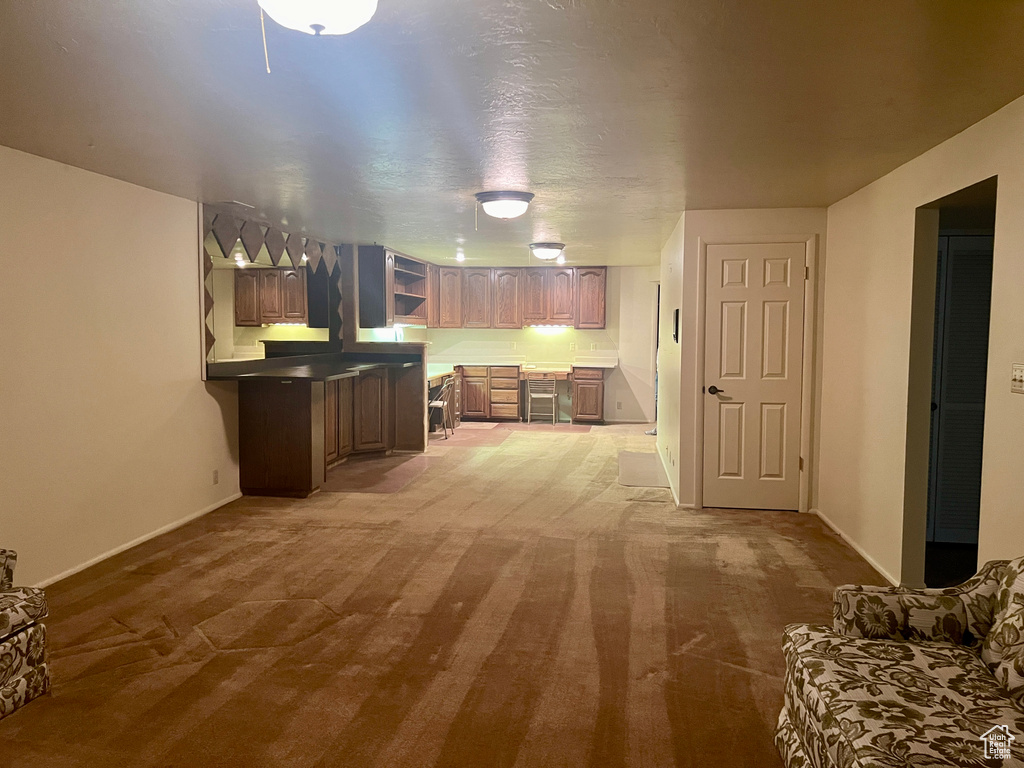 Kitchen featuring carpet floors and kitchen peninsula