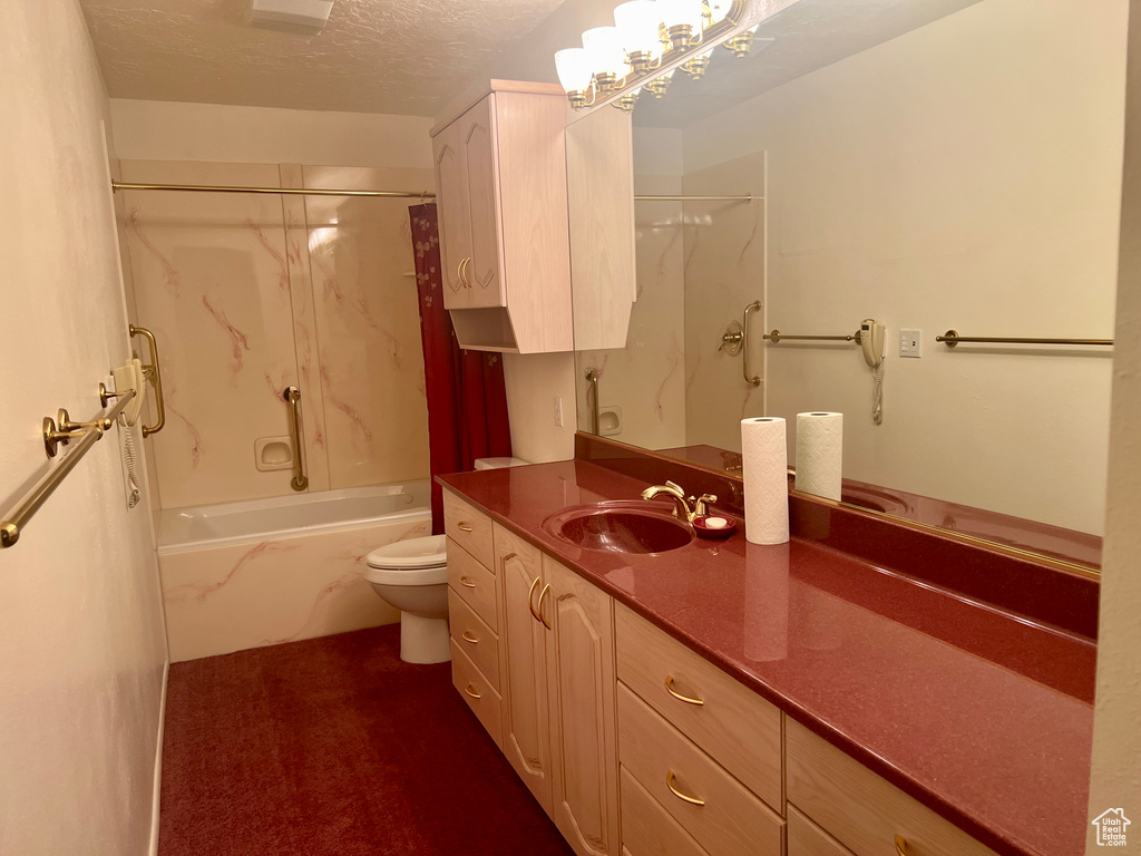 Full bathroom featuring vanity, shower / tub combo with curtain, a textured ceiling, and toilet