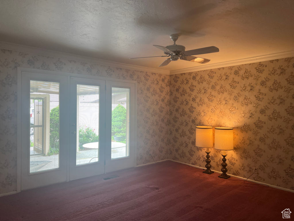 Carpeted spare room with crown molding and ceiling fan