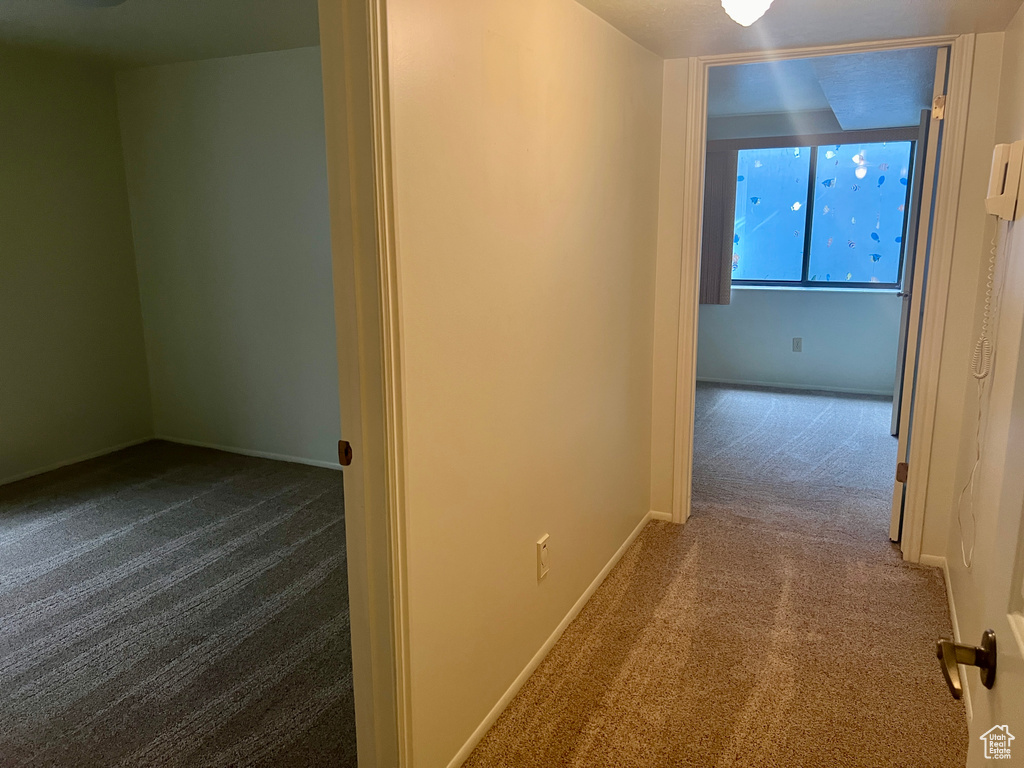 Hall featuring dark colored carpet