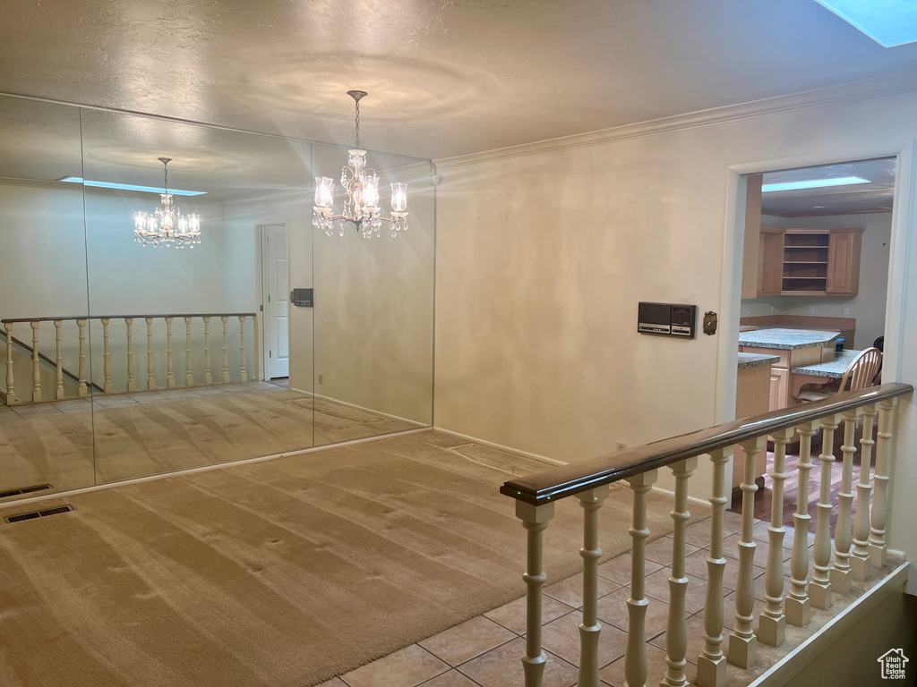 Stairway featuring a notable chandelier, carpet, and crown molding