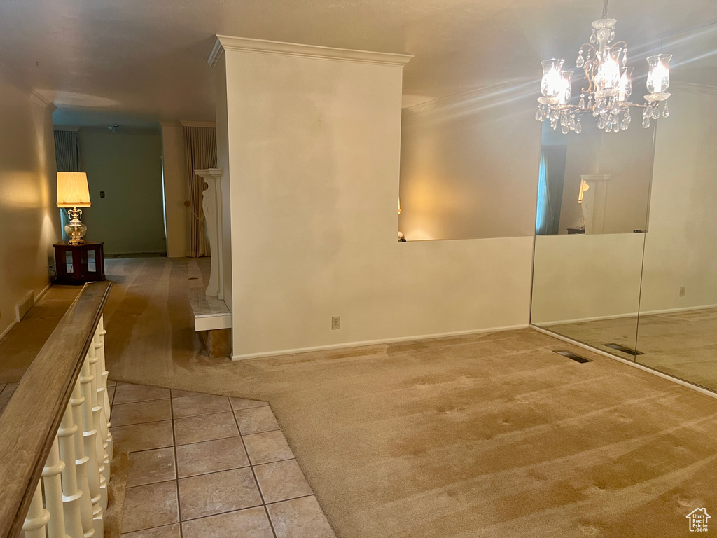 Interior space with carpet flooring, a notable chandelier, and crown molding