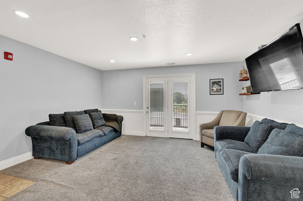 Carpeted living room featuring a textured ceiling