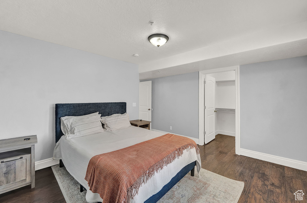 Bedroom featuring dark hardwood / wood-style flooring, a closet, and a spacious closet