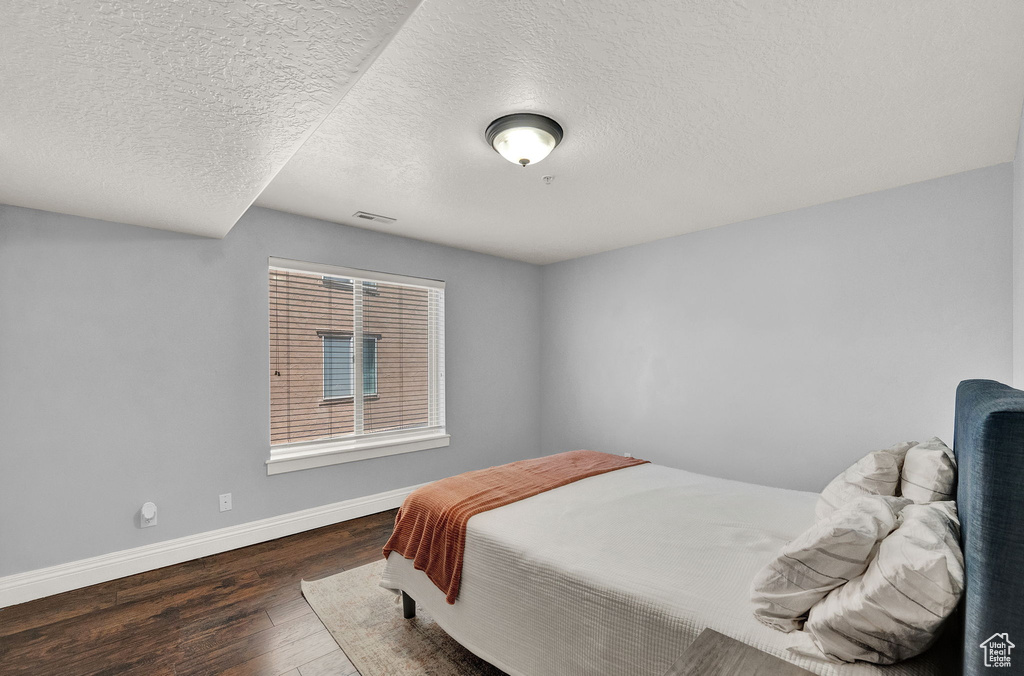 Bedroom featuring dark wood-type flooring and a textured ceiling