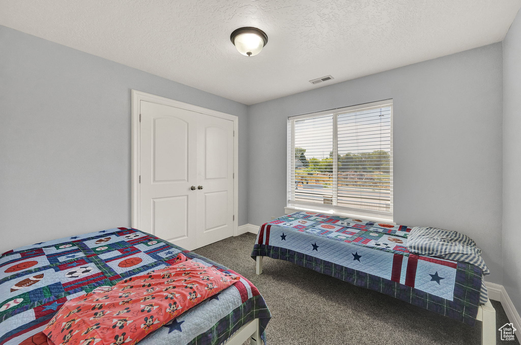 Carpeted bedroom featuring a textured ceiling