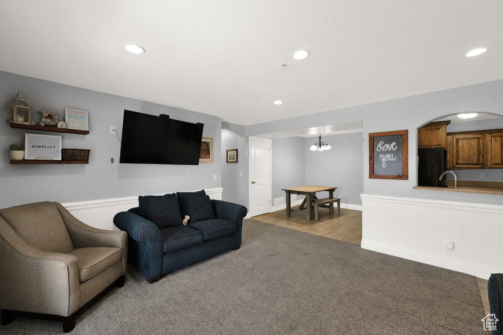 Carpeted living room with sink and a chandelier