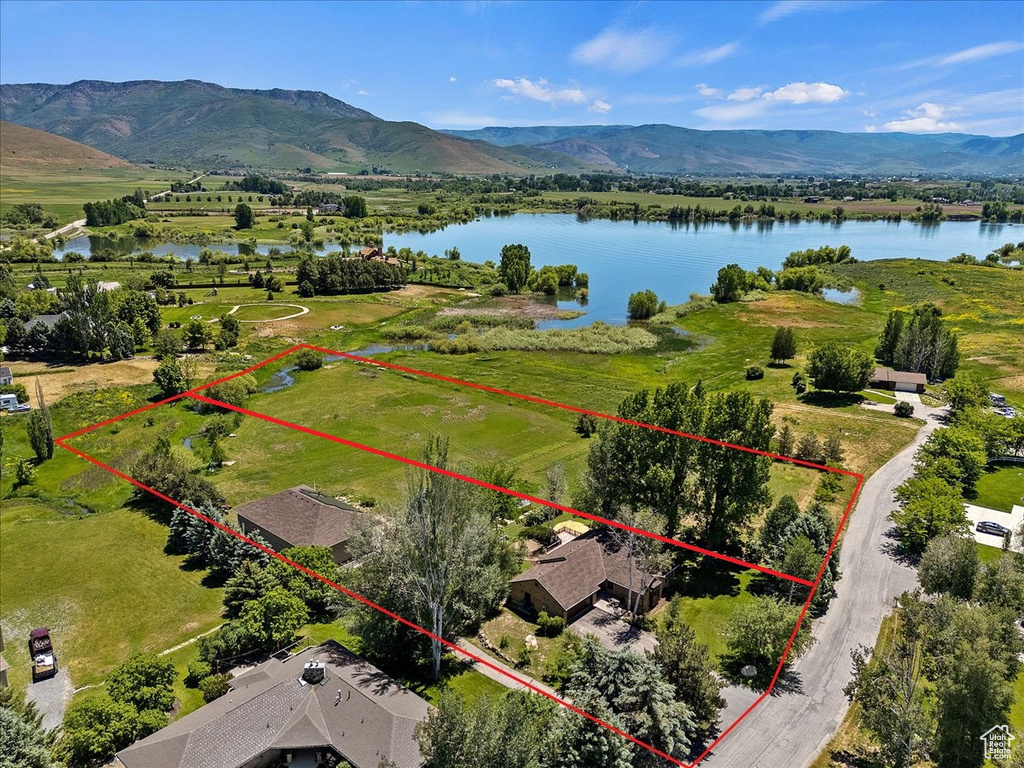 Birds eye view of property with a water and mountain view and a rural view