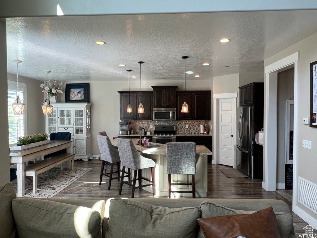 Living room featuring dark hardwood / wood-style flooring, sink, and a textured ceiling