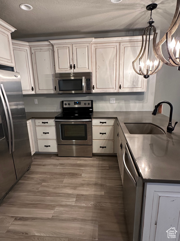 Kitchen featuring a sink, stainless steel appliances, and dark countertops