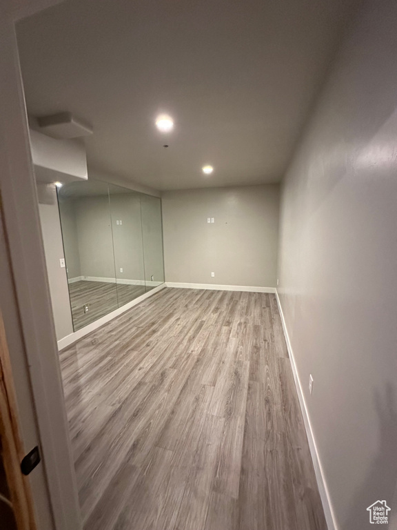 Finished below grade area with wood finished floors, baseboards, and recessed lighting