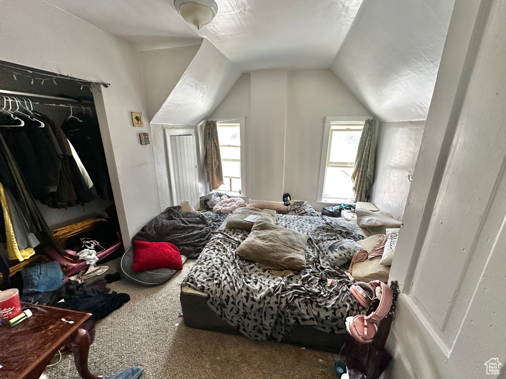 Carpeted bedroom featuring lofted ceiling