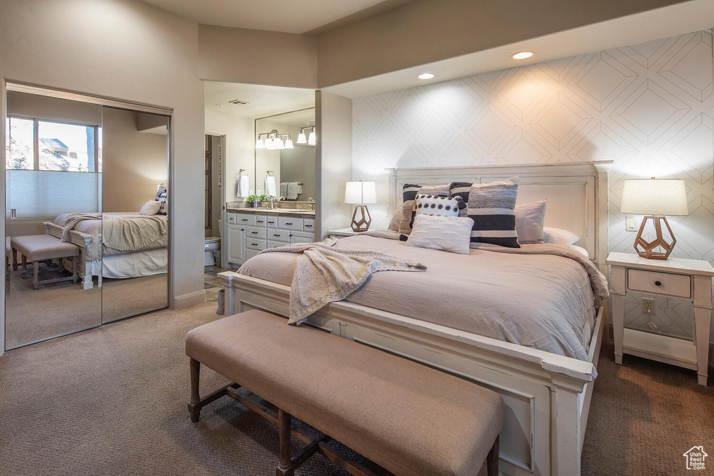 Bedroom featuring dark carpet and ensuite bath