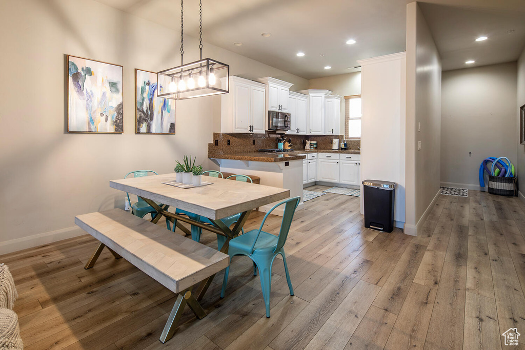 Dining room with an inviting chandelier and light hardwood / wood-style floors