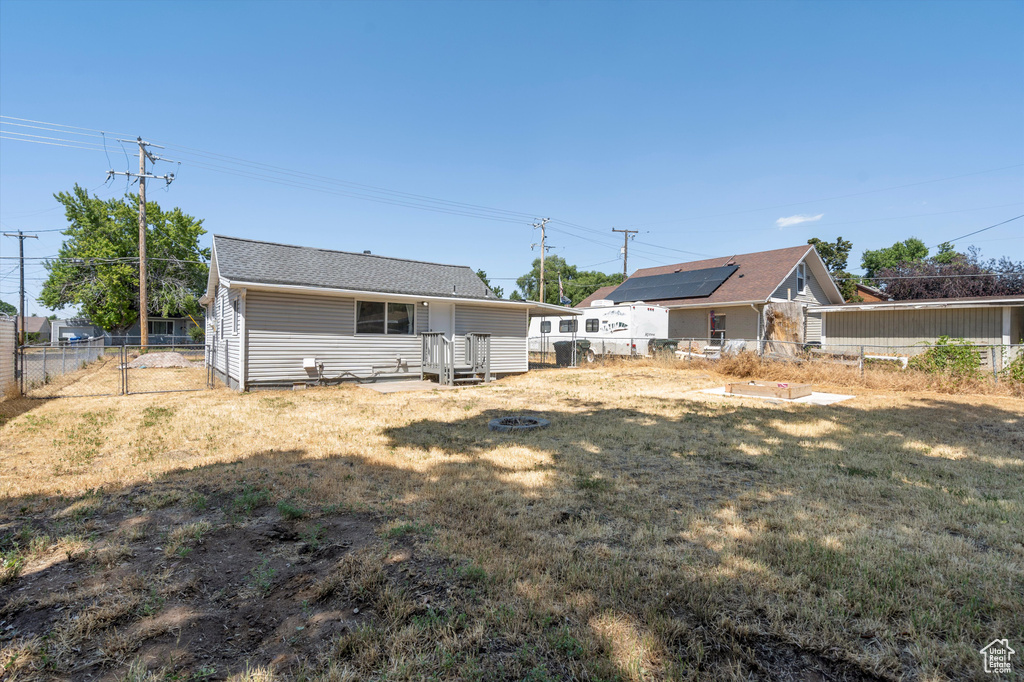 Back of property with a yard and solar panels