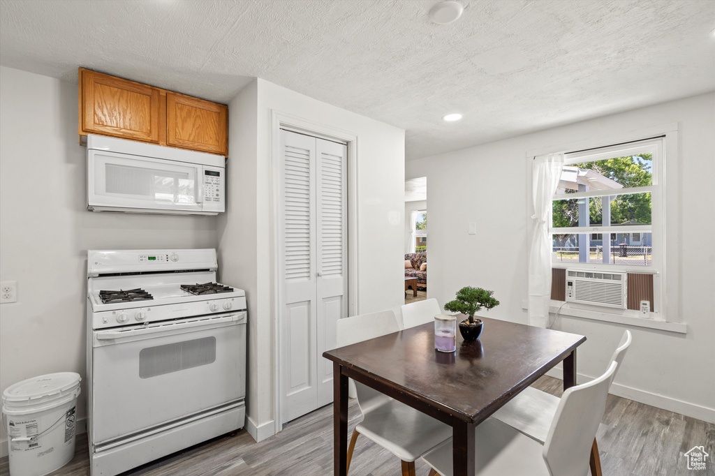 Kitchen featuring cooling unit, light wood-type flooring, and white appliances