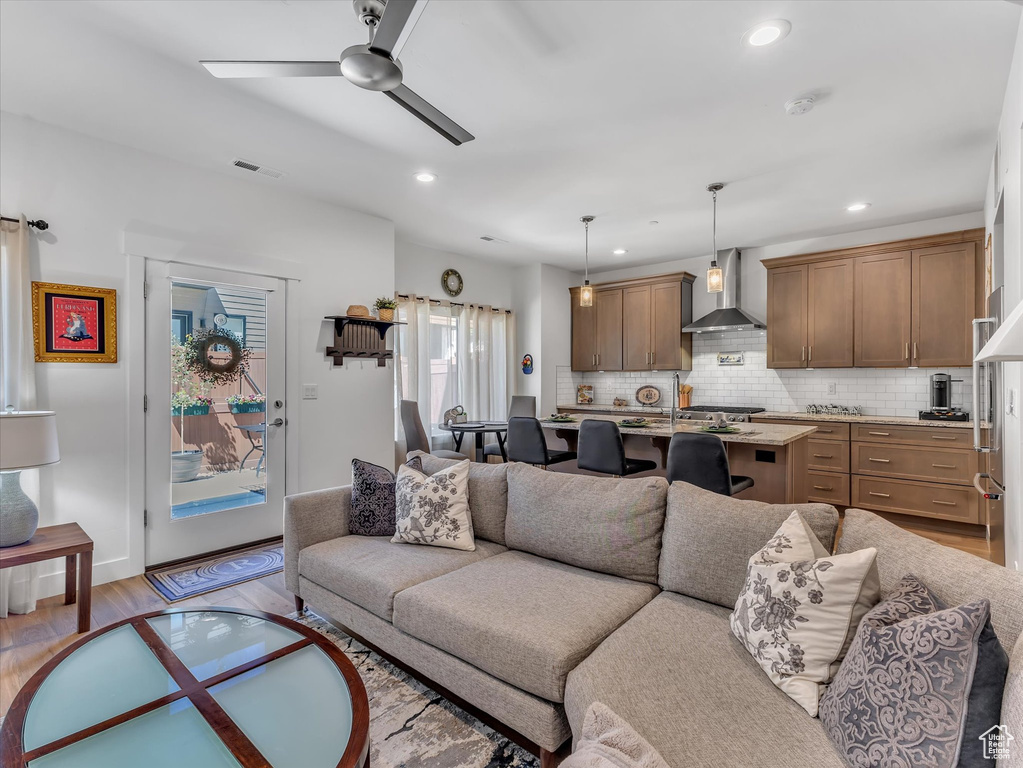 Living room featuring ceiling fan and light hardwood / wood-style flooring