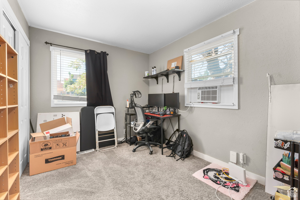 Carpeted office space featuring plenty of natural light and cooling unit