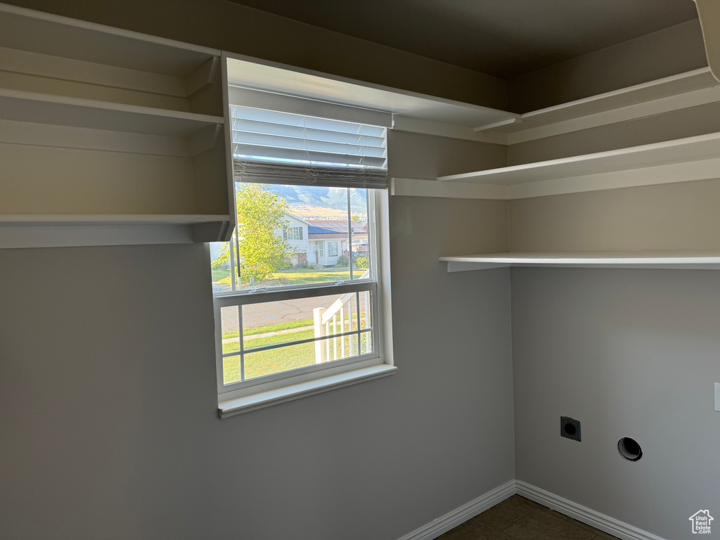 Laundry area featuring electric dryer hookup and dark tile patterned floors