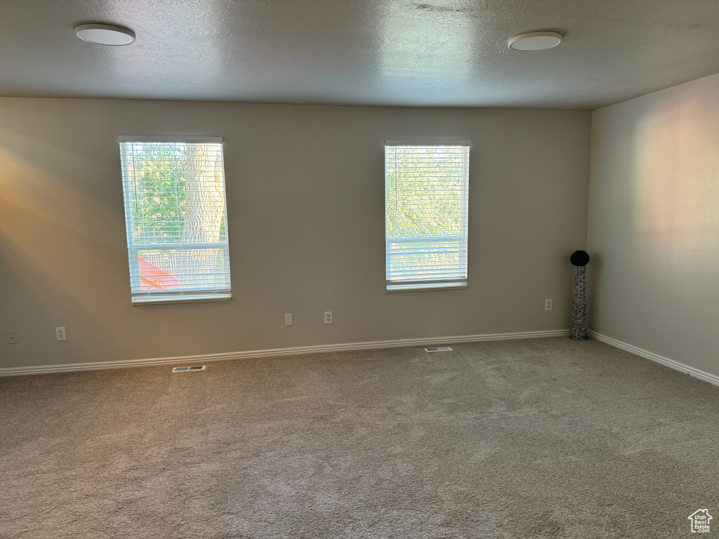 Carpeted empty room with a textured ceiling