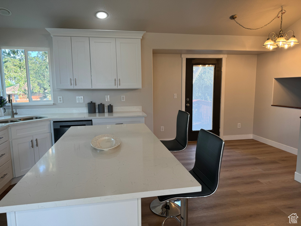 Kitchen with white cabinets, pendant lighting, sink, and a kitchen island