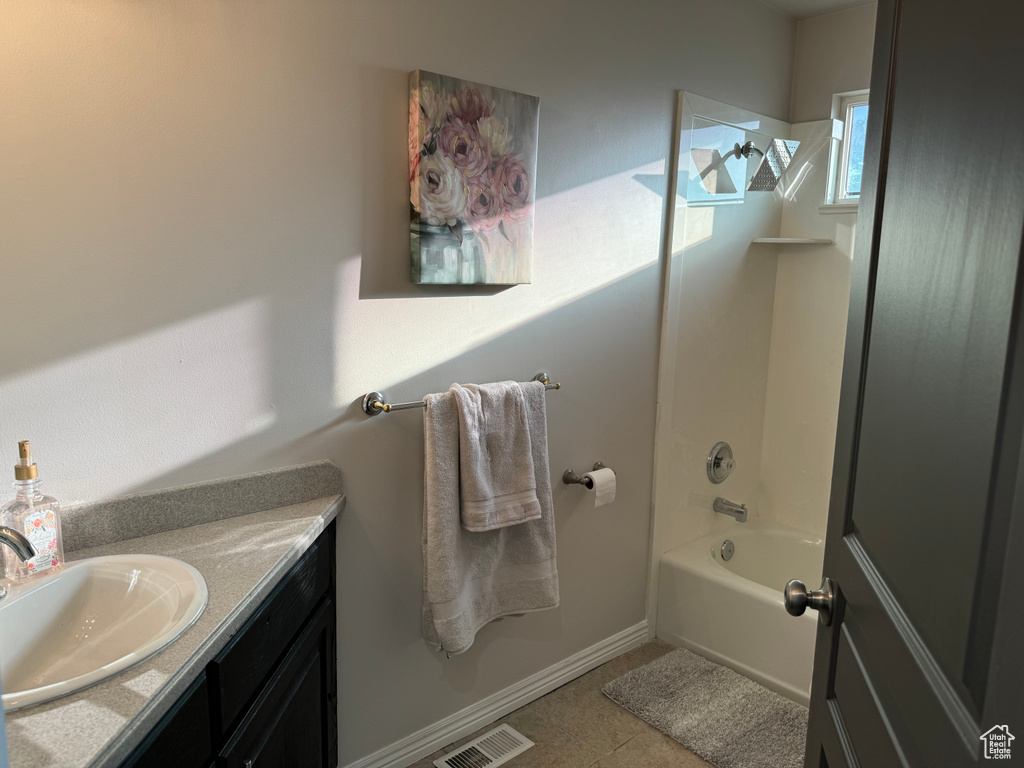 Bathroom with tile patterned flooring, bathing tub / shower combination, and vanity