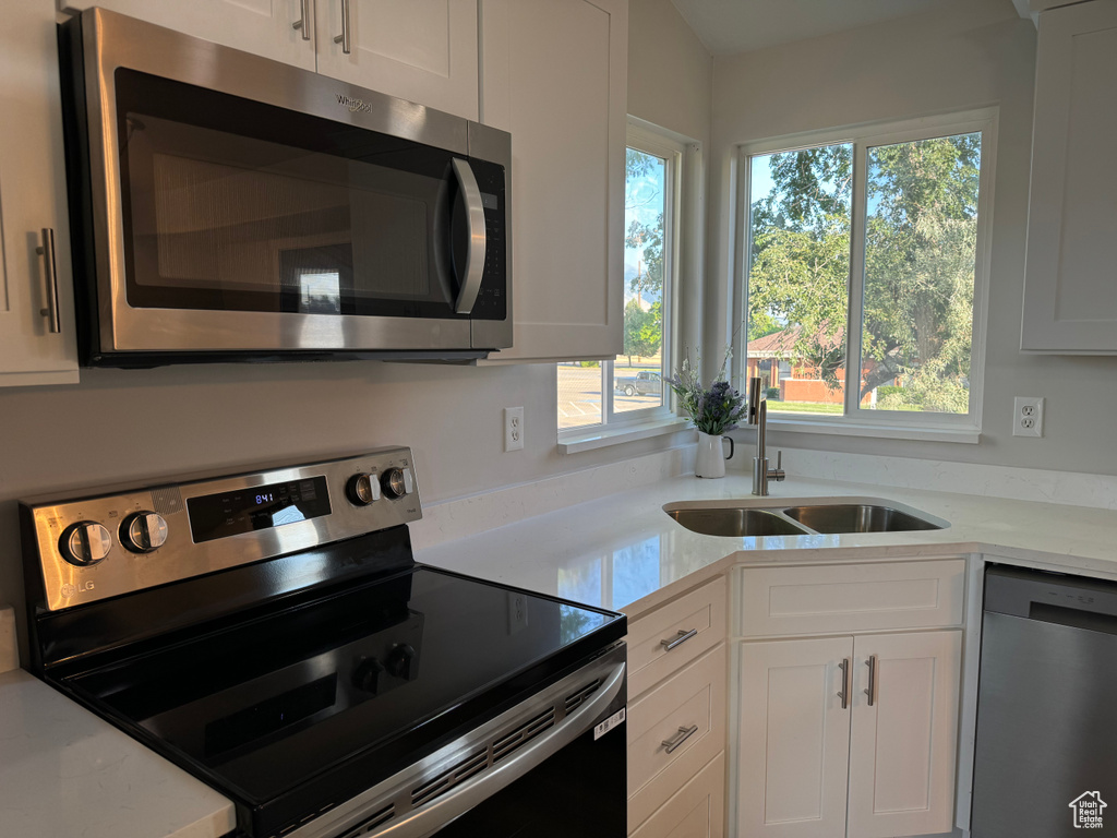 Kitchen featuring white cabinetry, stainless steel appliances, and sink